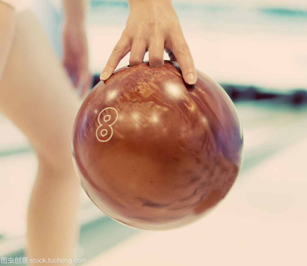 女人的手拋球在保齡球俱樂部